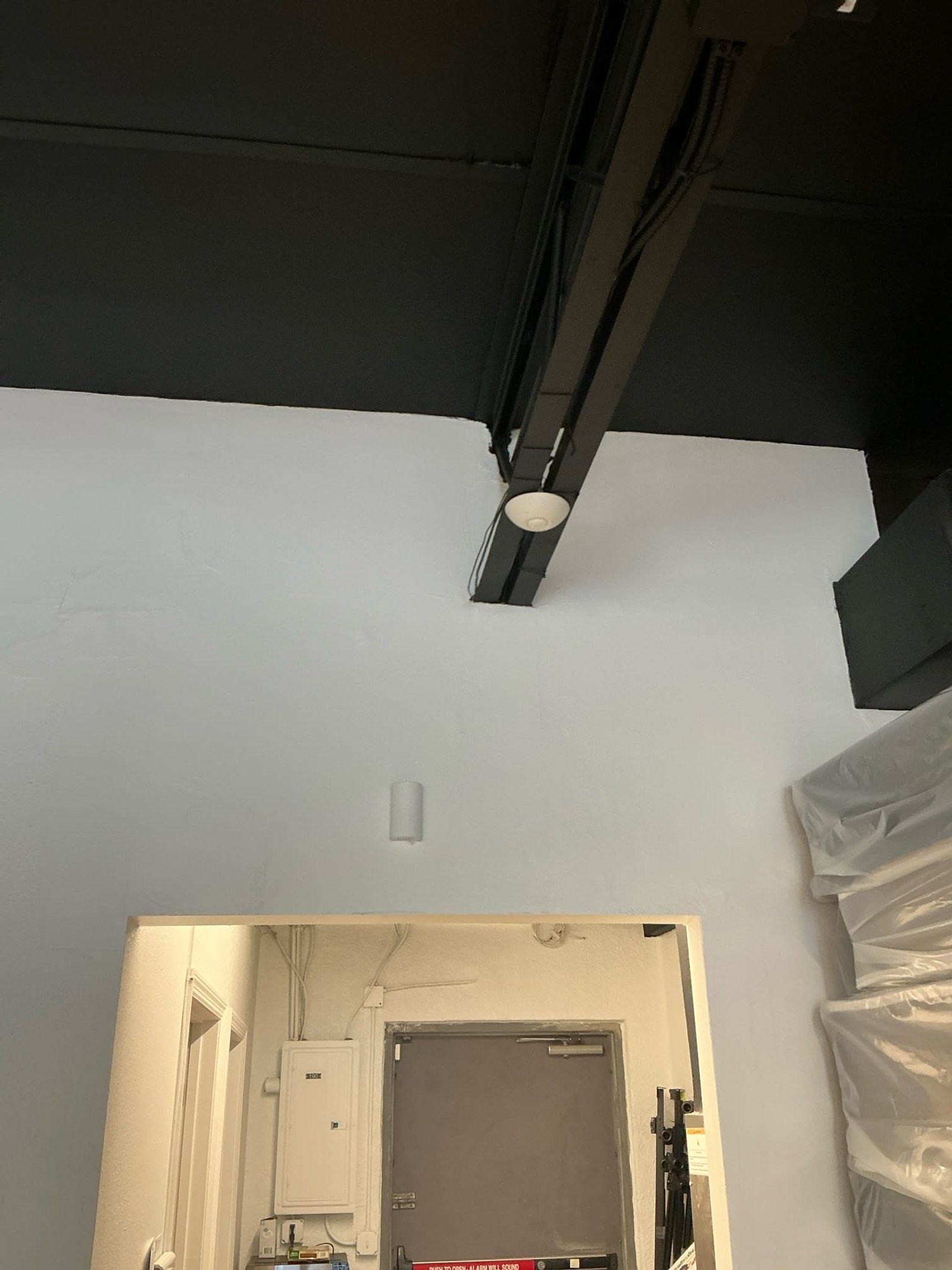 Interior room view showing missing smoke detector in required area and exposed ceiling infrastructure.