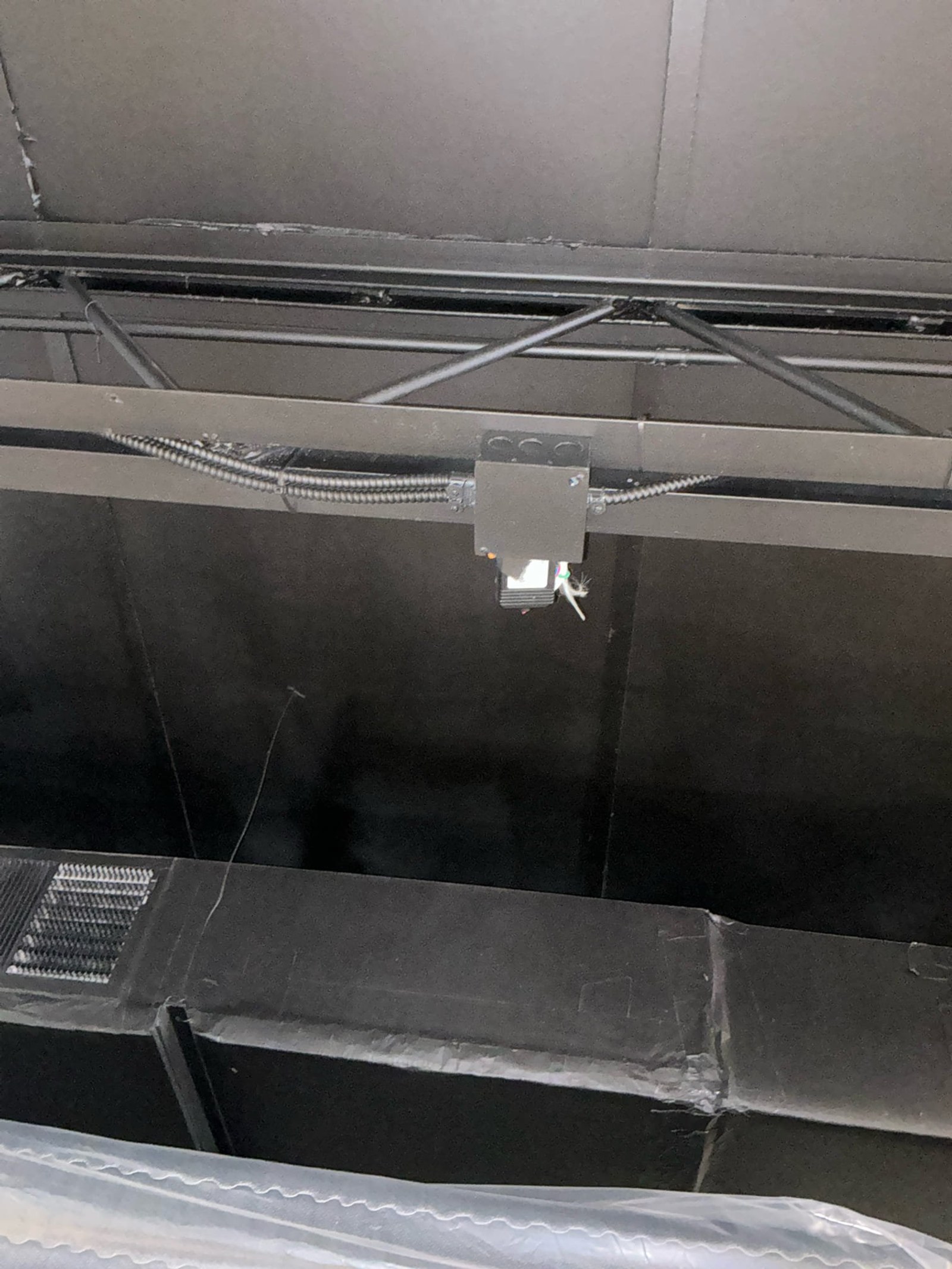 Ceiling plenum space showing flexible conduit with improper connector and exposed wiring lacking adequate strain relief.