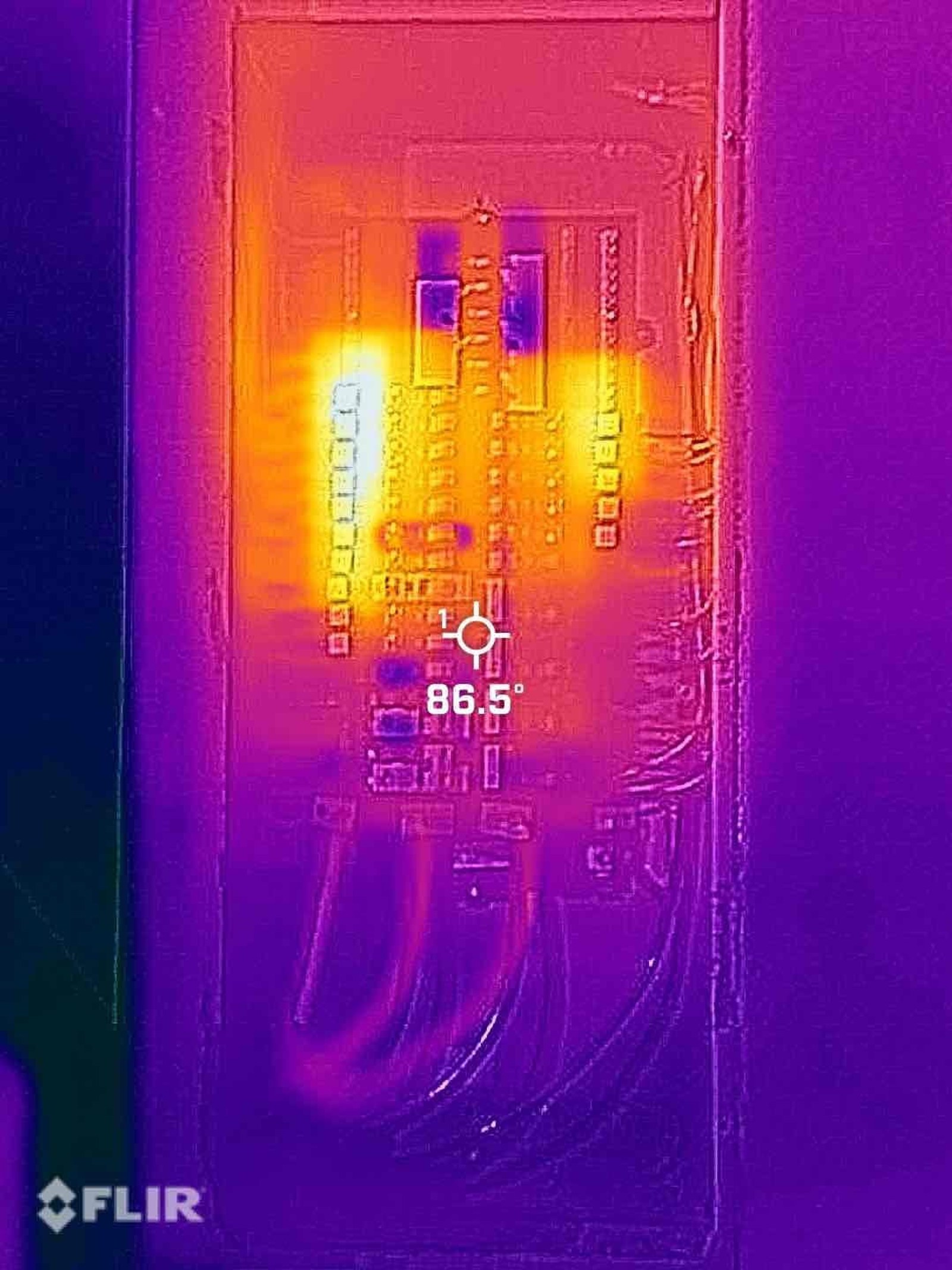 FLIR thermal image of switch plate showing elevated temperature reading of 86.5 degrees at outlet locations indicating potential connection issues.