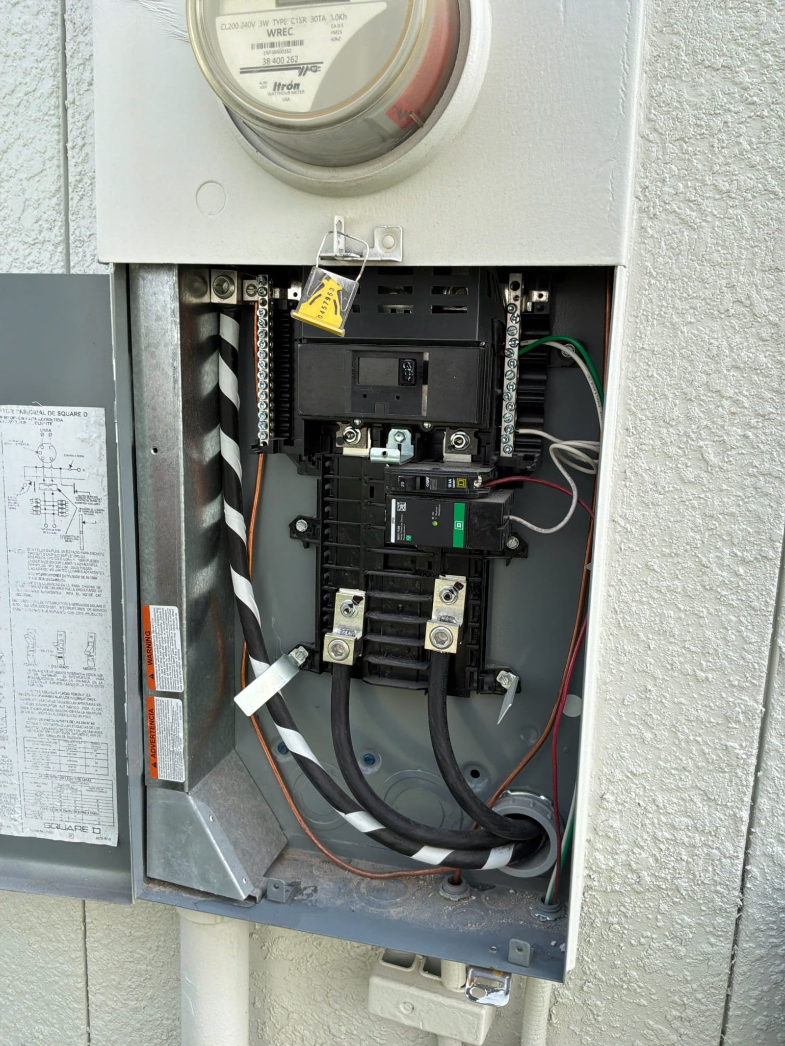 Meter and electrical service entrance panel with main disconnect and interior wiring visible.