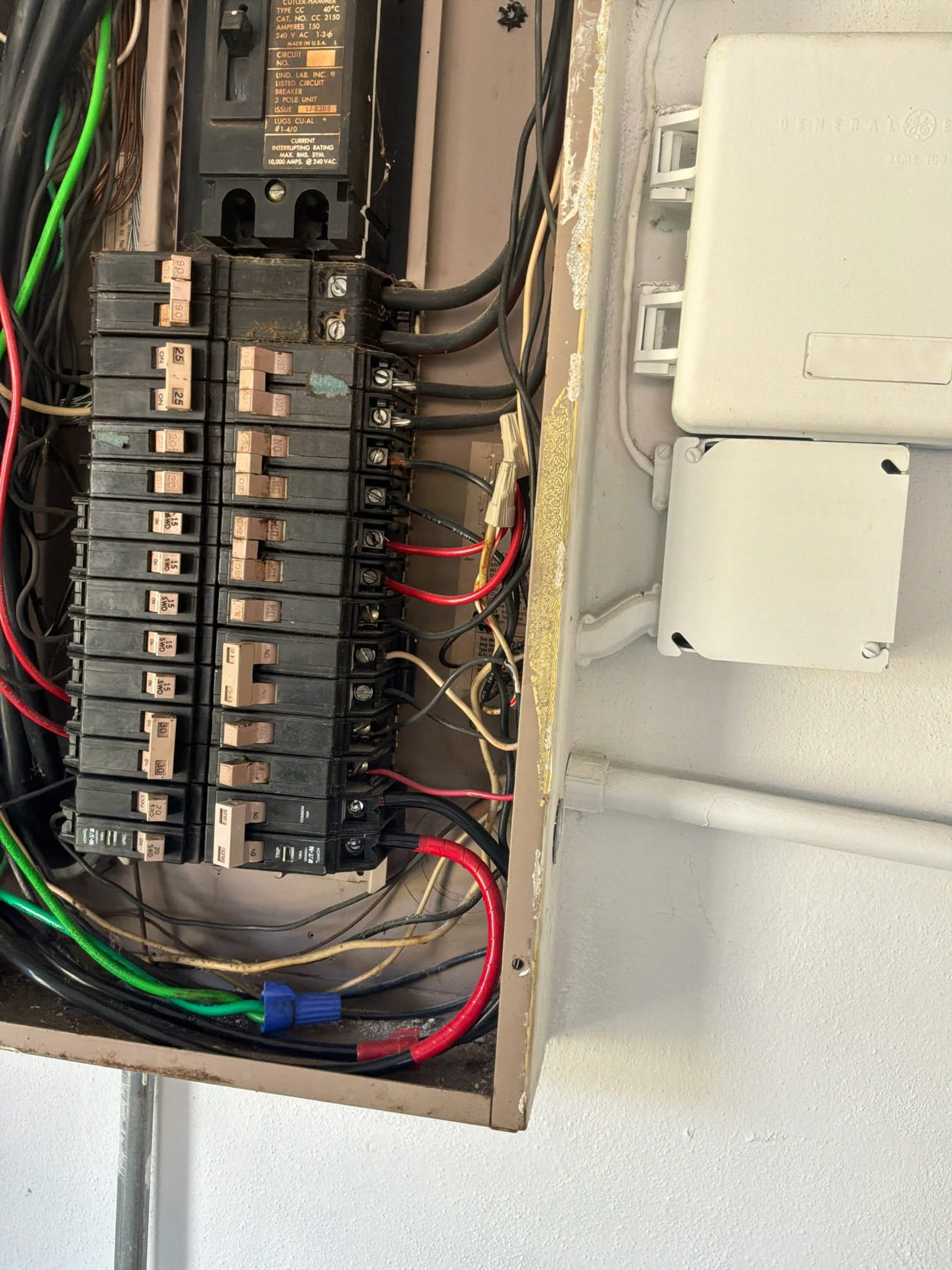 Breaker lugs and main disconnect area showing improper conductor routing and missing polarity identification on breaker terminals.