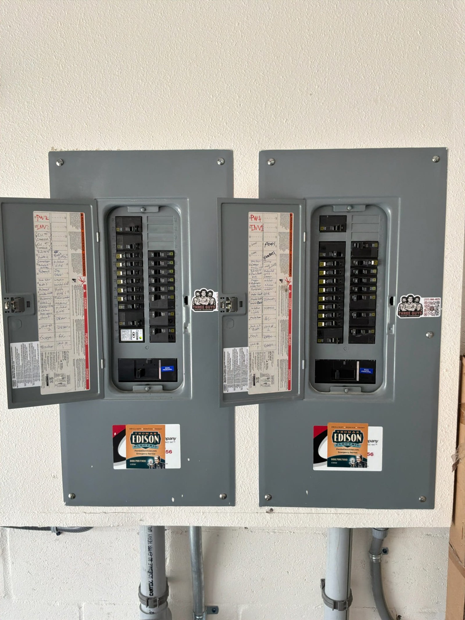 Two older Edison-type panels with handwritten circuit labels showing outdated electrical infrastructure and disorganized documentation.