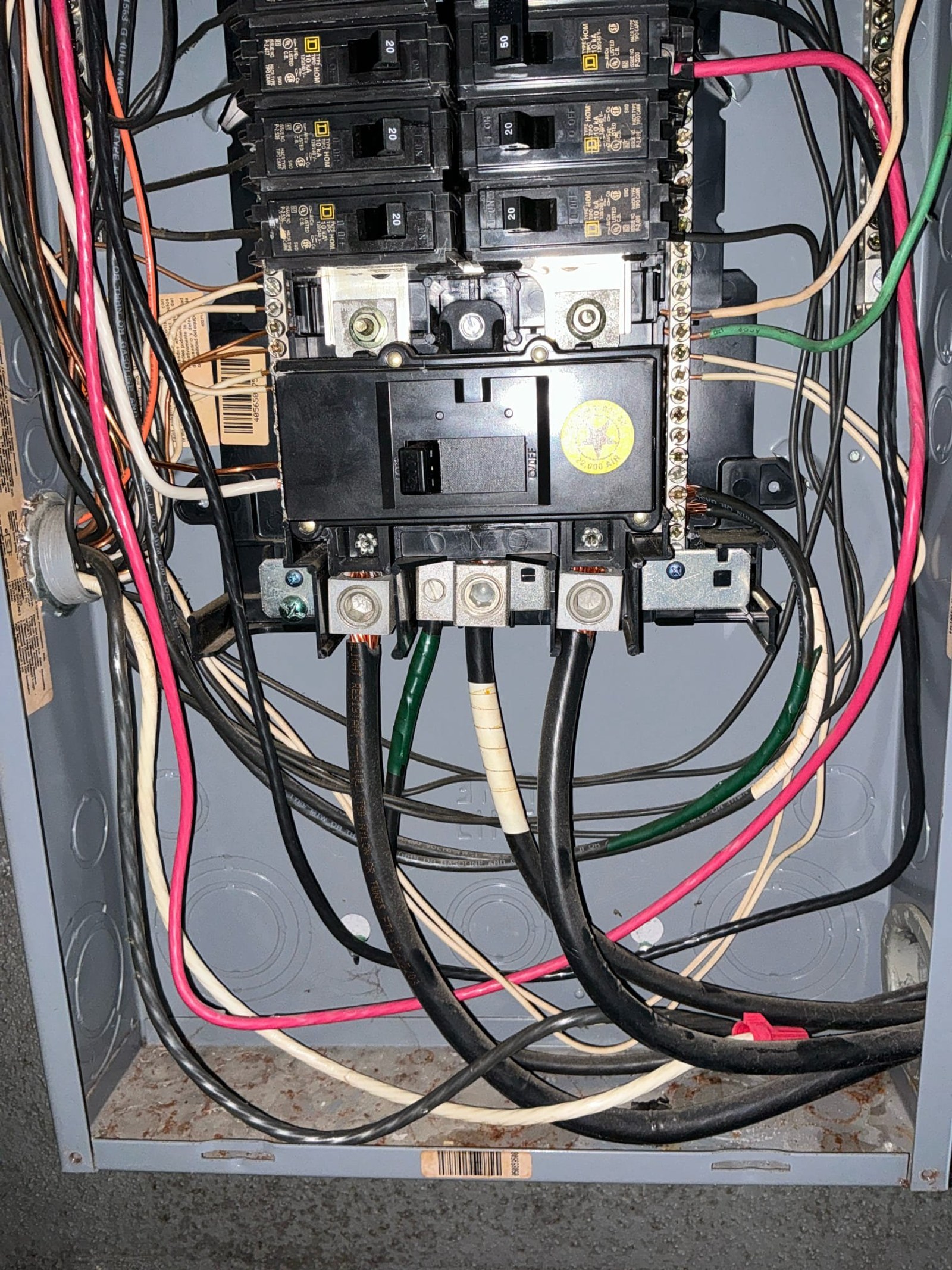 Panel interior showing multiple tandem breakers, backstabbed connections, and improper wire routing with inadequate strain relief.