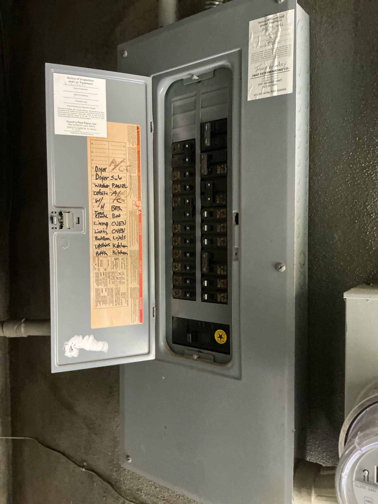 Panel interior with handwritten orange tag showing circuit labels; Notice of Inspection and equipment documentation visible on door.